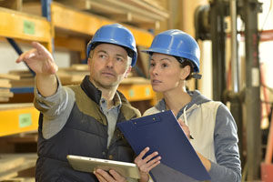 two people standing wearing hard hats