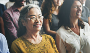 close up of a smiling woman sitting in a group of people