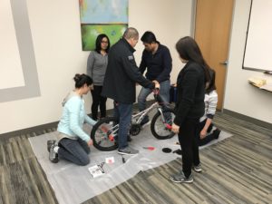 a group of six people building a bicycle